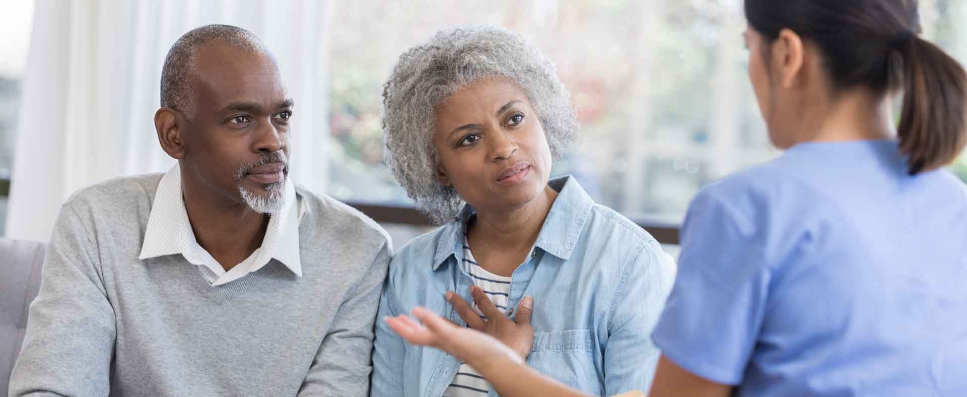 Health care professional talking with adult couple